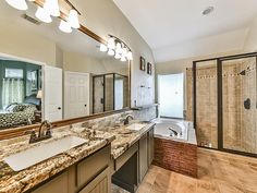 a large bathroom with granite counter tops and stone backsplashes on the walls