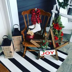 a wooden rocking chair sitting on top of a striped rug next to a christmas tree