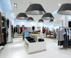 a clothing store with several lamps hanging from the ceiling