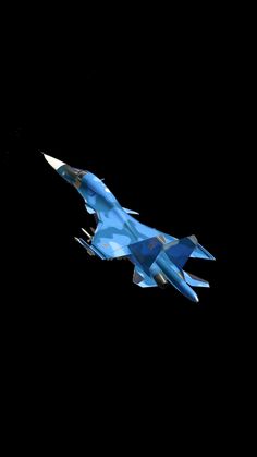 a blue fighter jet flying through the air at night with it's landing gear down