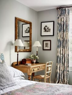 a bedroom with pictures on the wall and a desk in front of it next to a bed