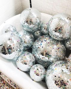 a bowl filled with shiny disco balls on top of a rug