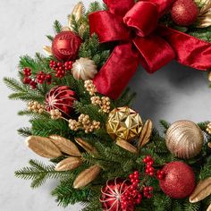 a christmas wreath with red and gold ornaments