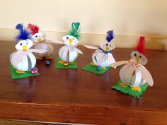 four paper birds with different colored feathers on them