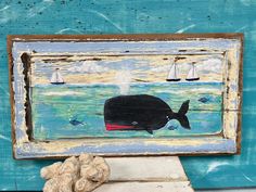 a whale painted on the side of a wall next to sea shells and a seashell