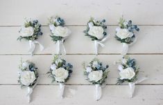 six boutonnieres with white and blue flowers on them