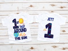 two t - shirts with the number one and first trip around the sun on them