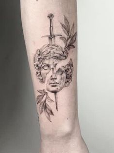 a woman's leg with a tattoo on it and a knife sticking out of her head