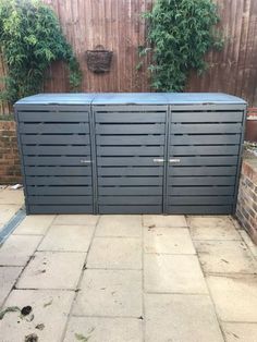 a large metal storage unit sitting in the middle of a yard with plants growing out of it