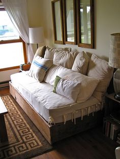 a living room with a couch, coffee table and two mirrors