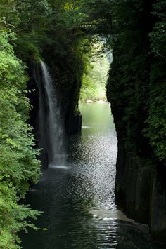 there is a small waterfall in the middle of this river that runs between two cliffs