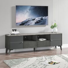 an entertainment center in a living room with a large painting on the wall above it