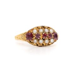 A Victorian garnet, pearl and yellow gold ring, comprising five cushion shaped garnets, and eight half seed pearls, set in 15 karat yellow gold, to a 15 karat yellow gold band.  My favourite thing about this Victorian Garnet and Pearl Ring, is the deep, luxurious red of the garnets. What's yours? Perhaps the shimmering pearls? Or the beautiful, engraved band?  This beautiful Victorian ring is set to the centre with 3 cushion shaped garnets, set East to West. A further pair of larger cushion shaped garnets, lead to the shoulders. The garnets are a deep, luxurious, wine red, and are well-matched with one another. 2 rows of 4 seed pearls are set above and below the garnets, the pale, shimmering pearls contrasting perfectly with the deep red and buttery yellow gold. The garnets are raised on a