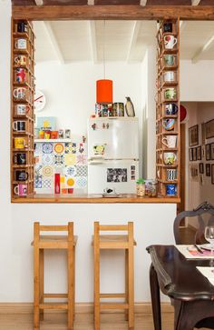 a kitchen with a table and chairs in front of a mirror that is hanging on the wall