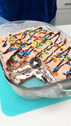 a piece of cake with chocolate frosting and sprinkles on it sitting in a pan