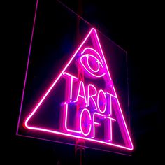 a neon sign with the words tarot loft on it's side in front of a dark background