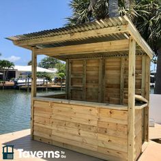 a wooden gazebo sitting on top of a pier next to the water and palm trees