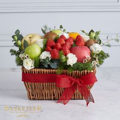 a basket filled with fruit and flowers on top of a table