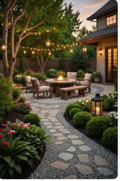 an outdoor dining area with lights strung over the table and chairs, surrounded by landscaping