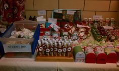 a table topped with lots of candy and christmas themed boxes filled with candies on top of a white table cloth