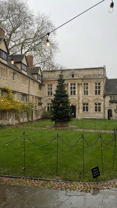 an old building with a large lawn in front of it and lights hanging from the ceiling