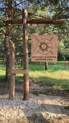 a wooden sign sitting in the middle of a forest