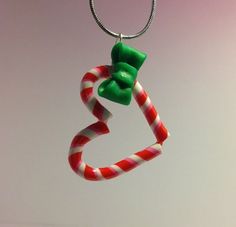 a candy cane keychain with a green bow hanging from it's end