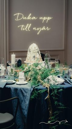 the table is set with candles and greenery