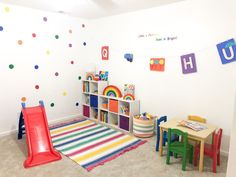 a child's playroom with toys, bookshelves and rugs on the floor