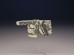 a dollar bill sticking out of the back of a tie on a stand with a black background