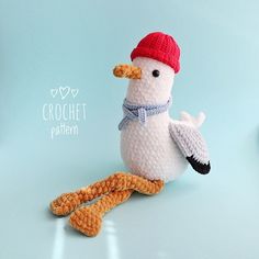 a crocheted stuffed bird with a red hat and scarf