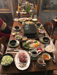 a long table with many plates and bowls on it