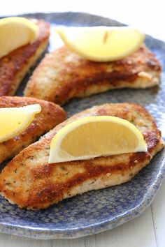 some food on a blue plate with lemon slices