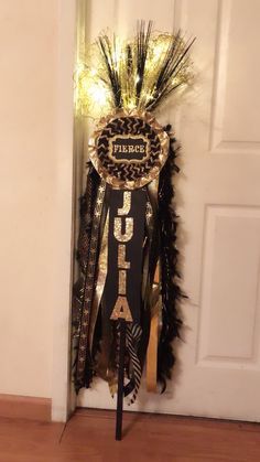 the door is decorated with black feathers and gold trimmings, which reads laurel