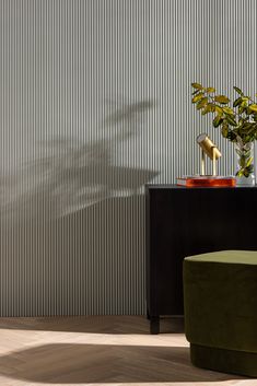 a green chair sitting next to a black table with a plant on top of it