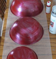 three red plates sitting on top of a wooden table