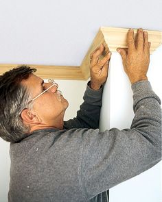 a man is working on the ceiling in his home