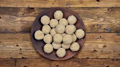 a brown plate filled with balls of food on top of a wooden table next to a wall