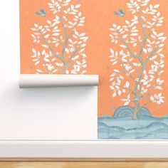 an orange wall with two trees and birds painted on it