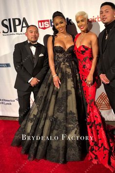 two men and a woman standing on a red carpet