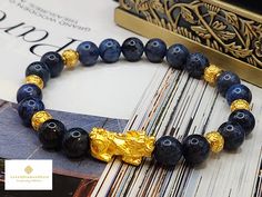 Gift yourself or your loveonce this beautiful bracelet. Crafted with 24 Karat Real Gold and Dumortierite. Metal: 24K Gold (Au999) Colour: Yellow Gold Gold Weight: Approximately 1.30gram Stone/Crystal Size: Approximately 8.3mm Metal is Made of Real 24K Gold. Never Gold Filled. Never Gold Plated.  🧧Pixiu is a powerful Feng Shui symbol of wealth. It is believed that wearing the symbol of Pixiu brings money and good fortune to its wearer. This mythical creature is also thought to protect people fro Spiritual Gold Bracelet With Round Beads As Gift, Luxury Gold Bracelet With Round Beads For Gift, Feng Shui Symbols, Gold Money, Spiritual Protection, Good Fortune, Protection Bracelet, Minimalist Bracelet, Real Gold