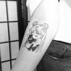 a black and white photo of a woman's arm with a cartoon character on it