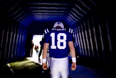 a man in a football uniform walking down a tunnel