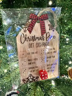 a wooden christmas ornament hanging on a tree with a red dice in front of it