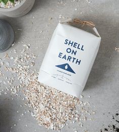 a bag of oatmeal sitting on top of a table next to a potted plant