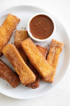 some fried food on a white plate with dipping sauce