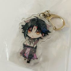 a keychain with an anime character on it's front and back sides