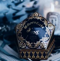 an ornate blue and gold box with the word chocolate on it sitting on a table