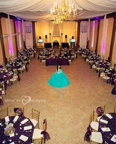 a room filled with tables and chairs covered in purple cloths