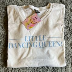 a t - shirt with the words little dancing queen on it sitting on a carpet